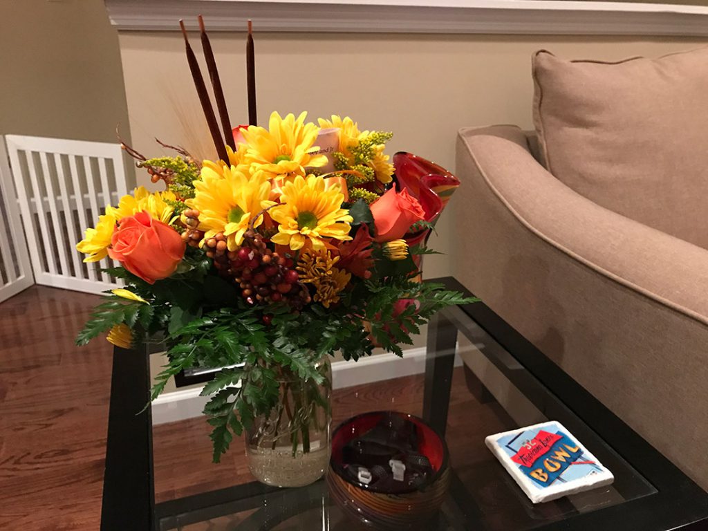 A bouquet of flowers on top of a glass table.